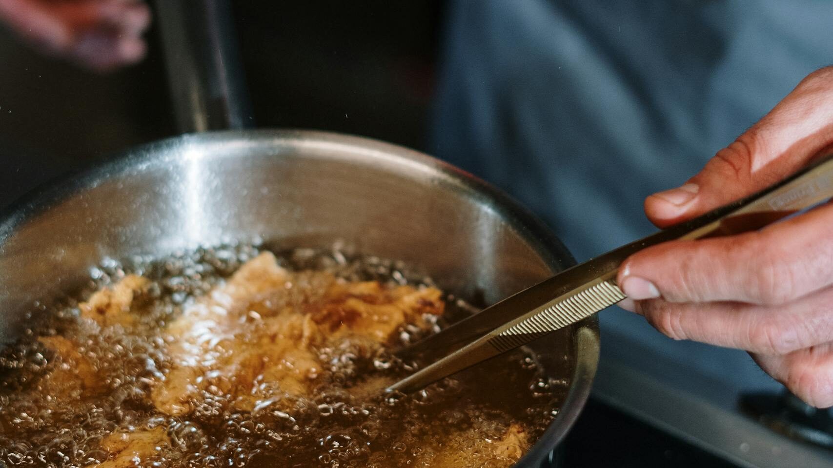 Person Holding Stainless Steel Cooking Pot